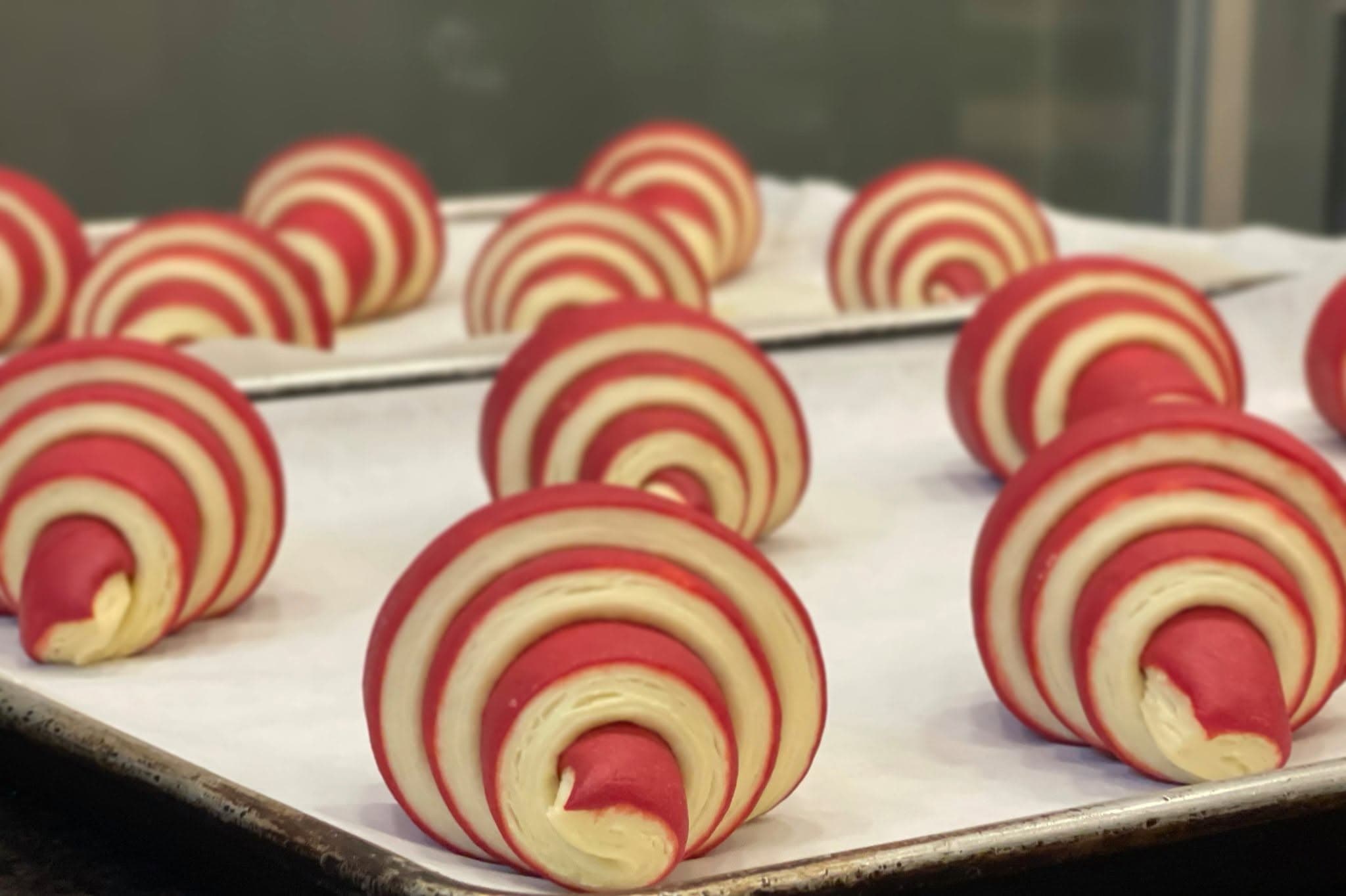 Two-tone croissants shaped and resting on a tray